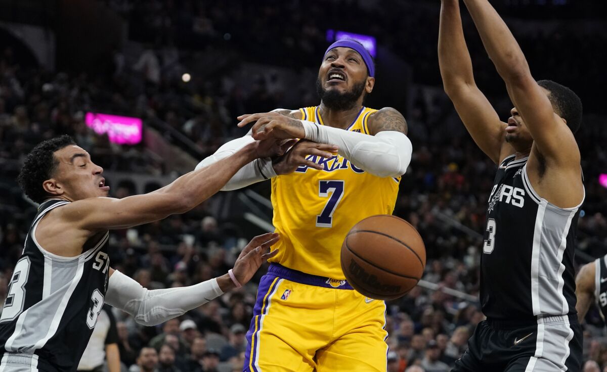 Lakers forward Carmelo Anthony is fouled as he drives to the basket against San Antonio Spurs' Tre Jones and Keldon Johnson.