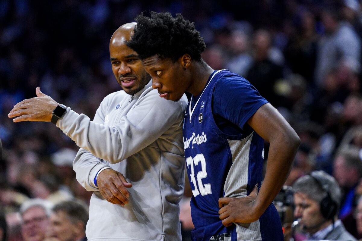 Saint Peter's coach Shaheen Holloway, left, talks with Jaylen Murray during a win over Purdue in the Sweet 16 on Friday.
