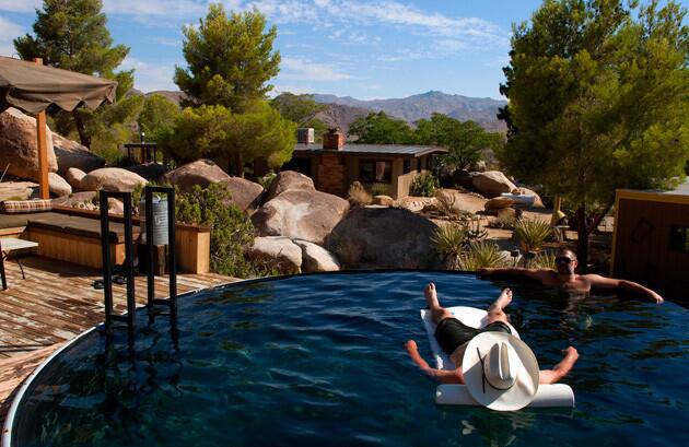 Steve Halterman is shaded by a cowboy hat as he floats in the pool, while Glenn Steigelman kicks back at the water's edge.