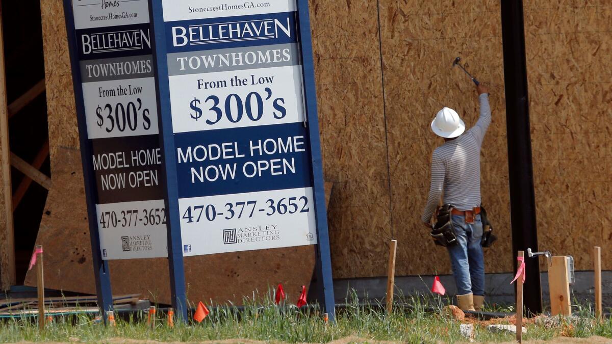 A construction worker continues work on new townhomes in Woodstock, Ga., on May 16.