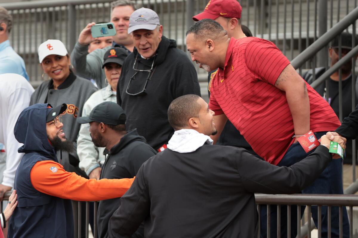 Keenan Allen, bottom left, shakes hands with Carl Williams, father of USC quarterback Caleb Williams, during USC pro day. 