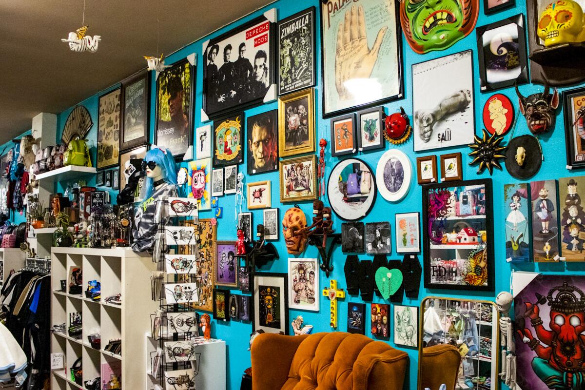 Halloween-themed art and items hung on a blue wall 