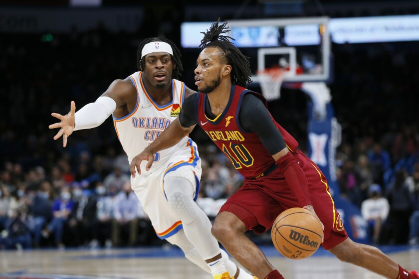 Cleveland Cavaliers guard Darius Garland (10) drives against Oklahoma City Thunder guard Luguentz Dort in the first half of an NBA basketball game Saturday, Jan. 15, 2022, in Oklahoma City. (AP Photo/Nate Billings)
