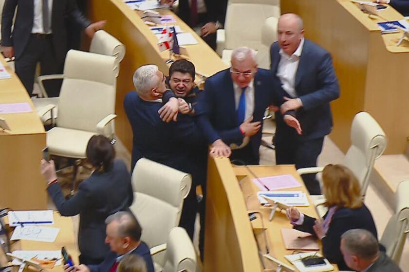 Foto tomada de video difundido por el Canal Mtavari el 14 de mayo de 2024, en que se ve a legisladores georgianos peleando en una sesión parlamentaria en Tiflis, Georgia. . (Canal Mtavari via AP)