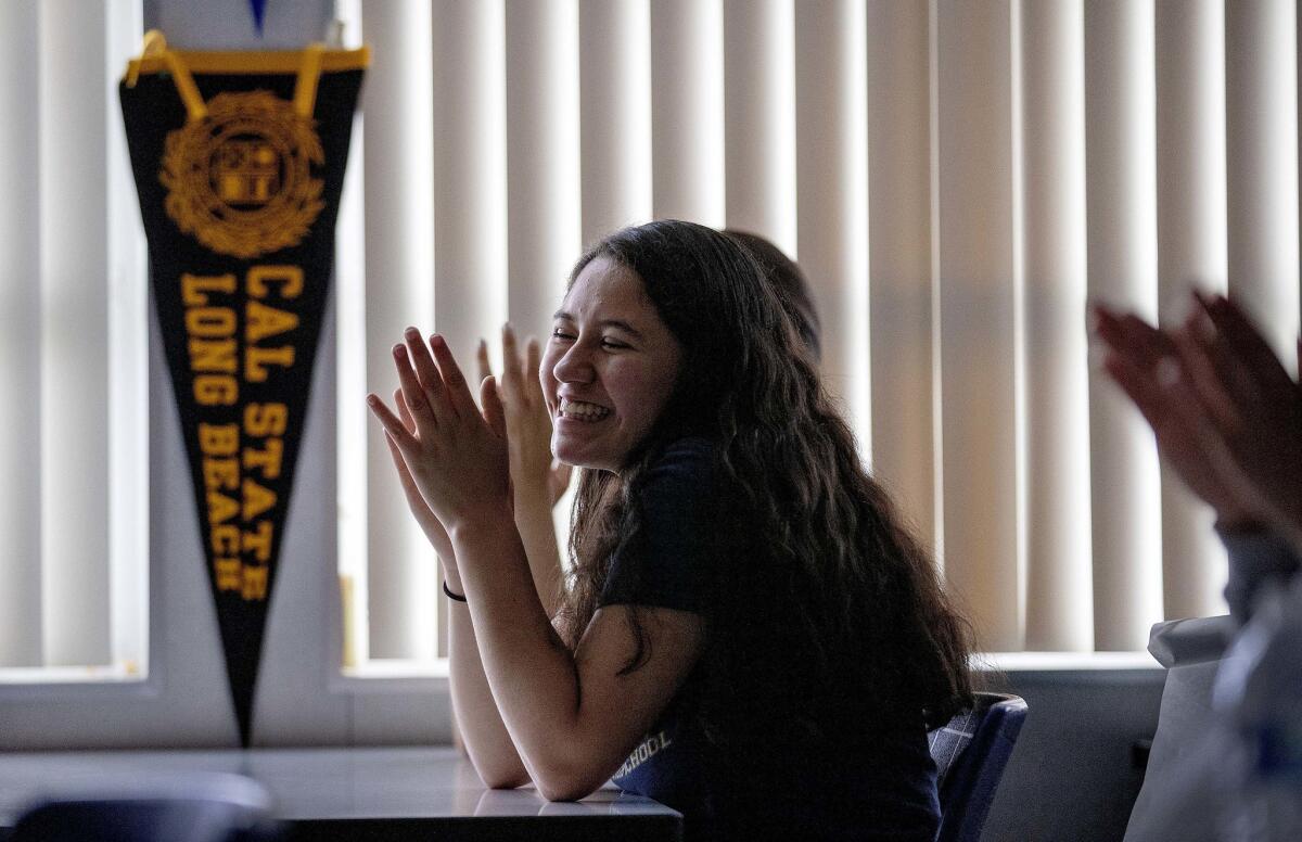 Katerin applauds a fellow student giving a speech as the class prepares for college entry at the IDEAS club.