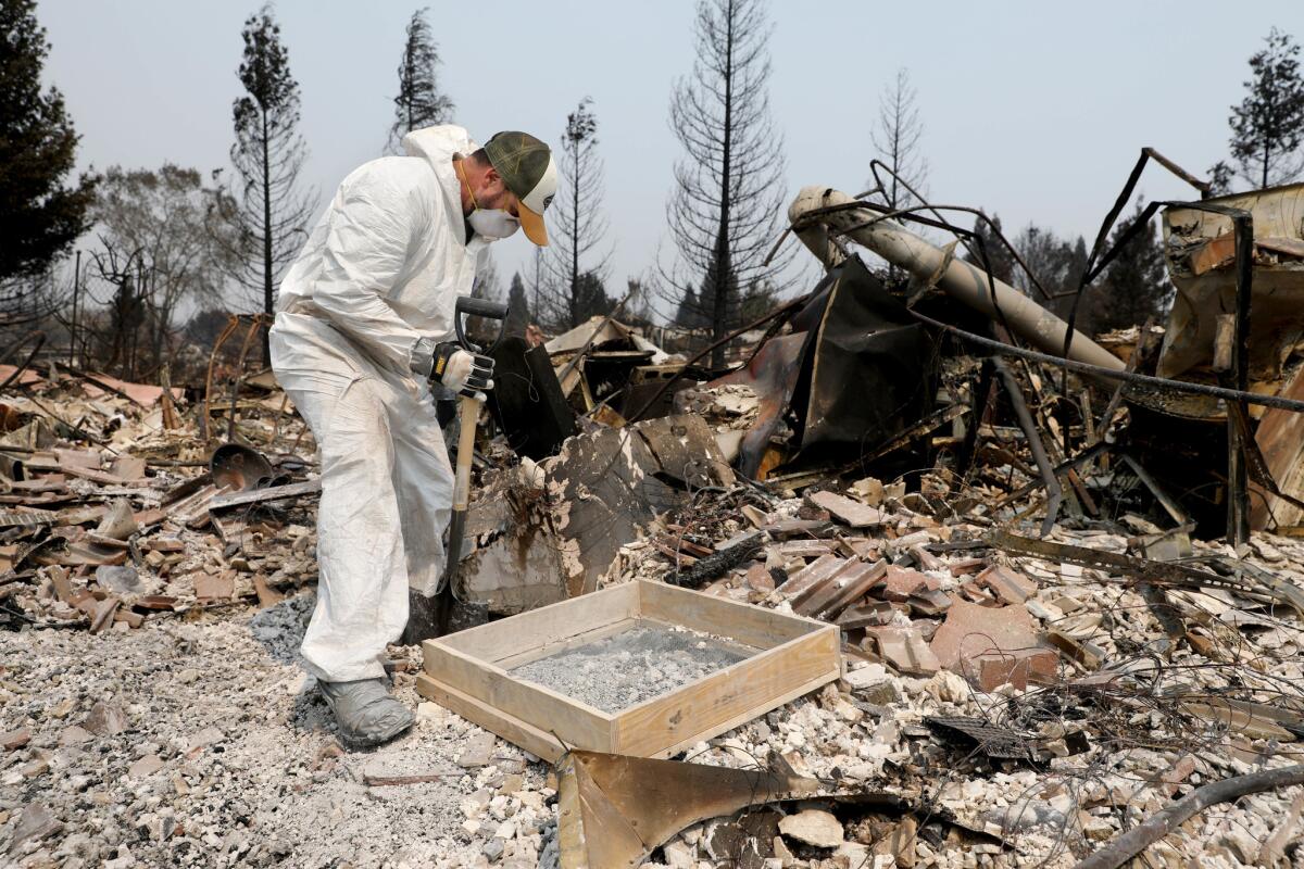 Scott Gregory looks for valuables at his home destroyed by the Carr fire in the Landpark Subdivision in Redding.