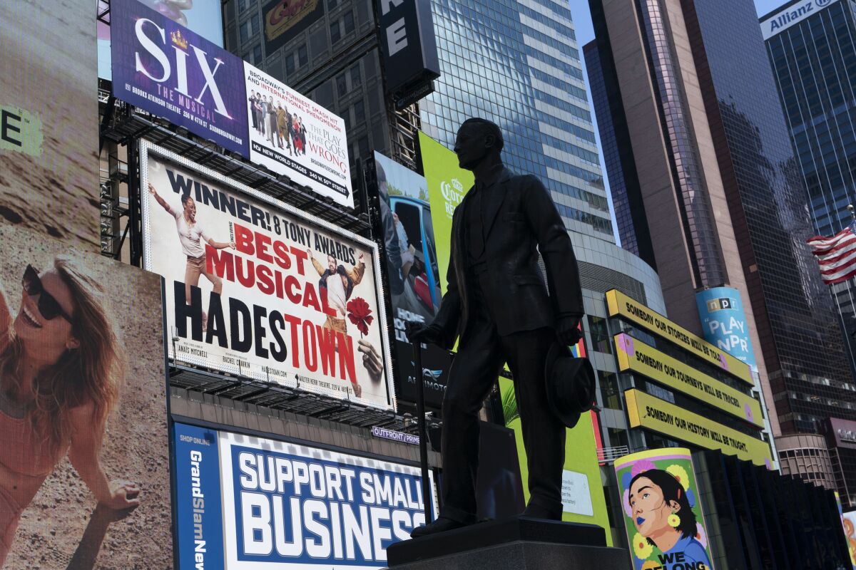 A statue of playwright and performer George M. Cohan stands in New York's Times Square in front of billboards for Broadway shows, Thursday, May 6, 2021. Gov. Andrew Cuomo has announced that Broadway theaters can reopen Sept. 14, 2021. (AP Photo/Mark Lennihan)
