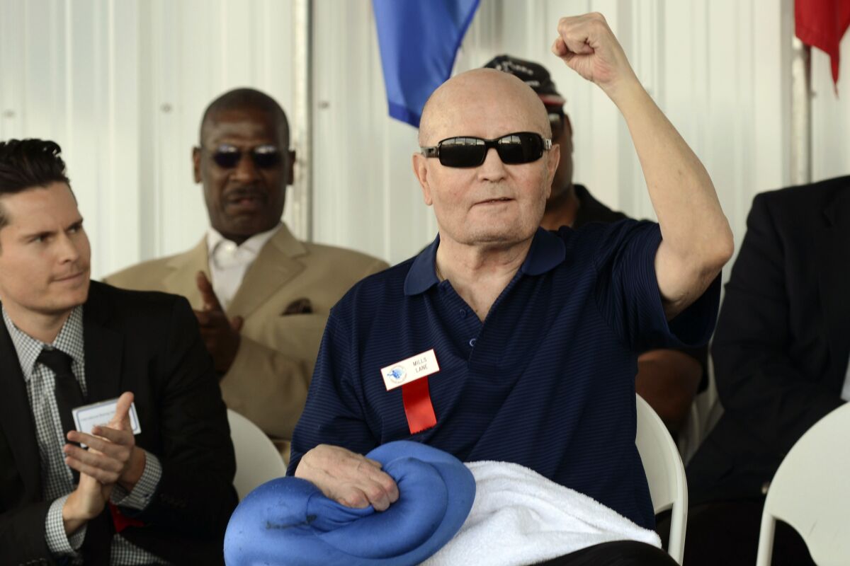 Boxing referee Mills Lane pumps his fist while being inducted into the International Boxing Hall of Fame.