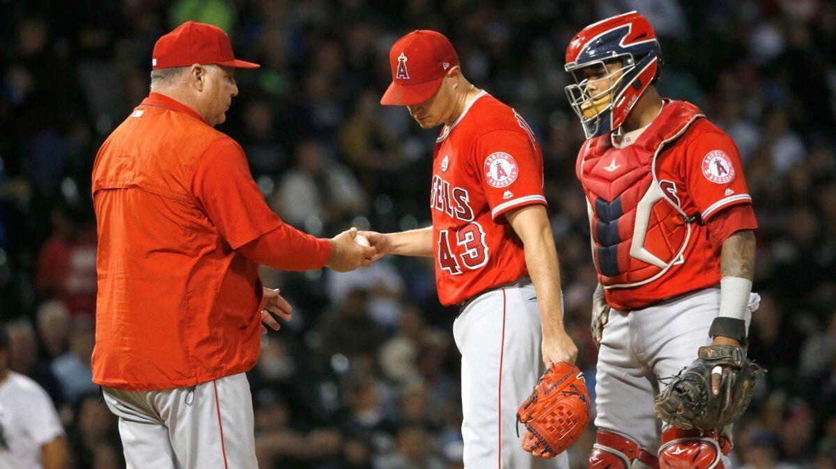 Angels manager Mike Scioscia, left, takes starting pitcher Garrett Richards out of the game as catcher Martin Maldonado watches during the fourth inning against the Chicago White Sox on Wednesday.