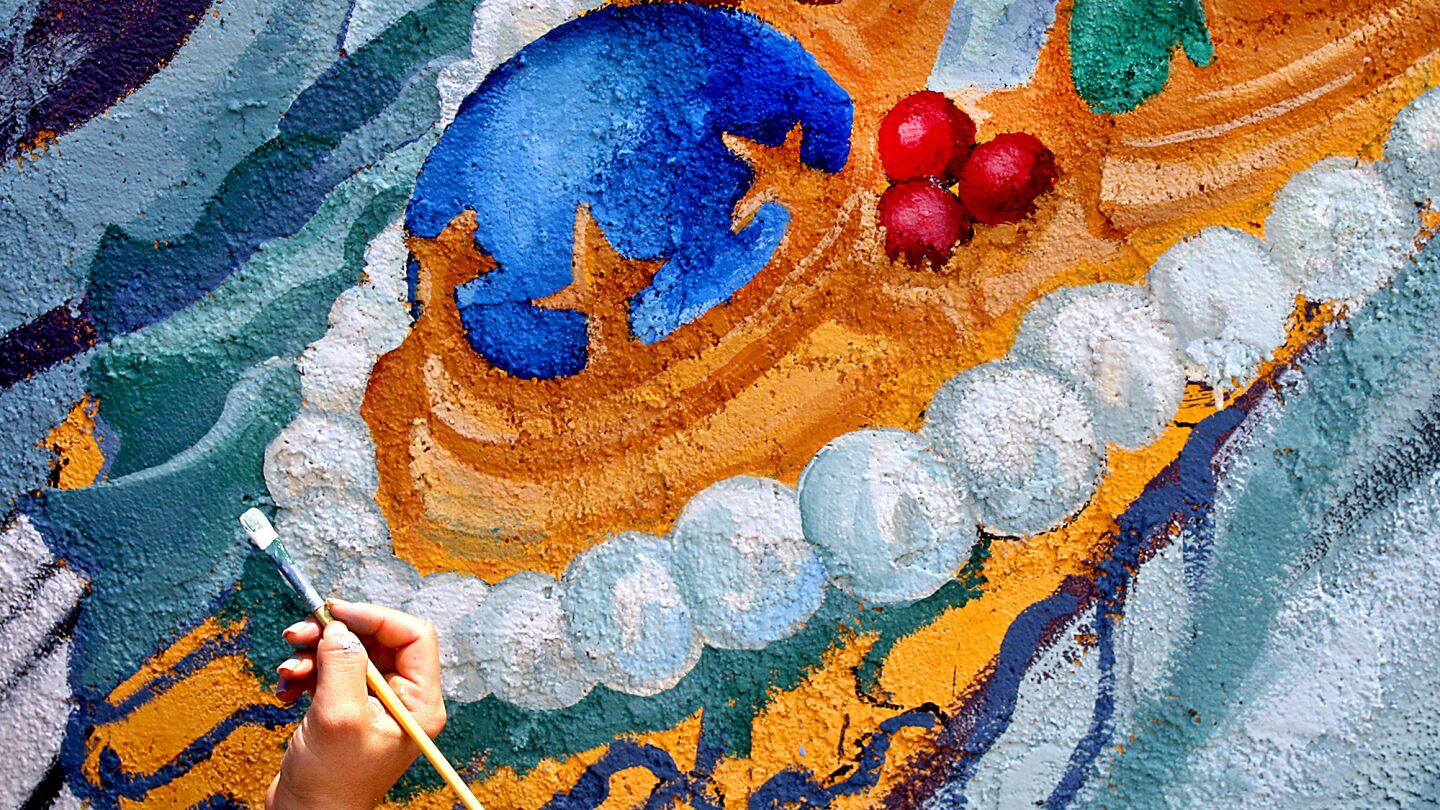 Rosa Lopez works on a mural.