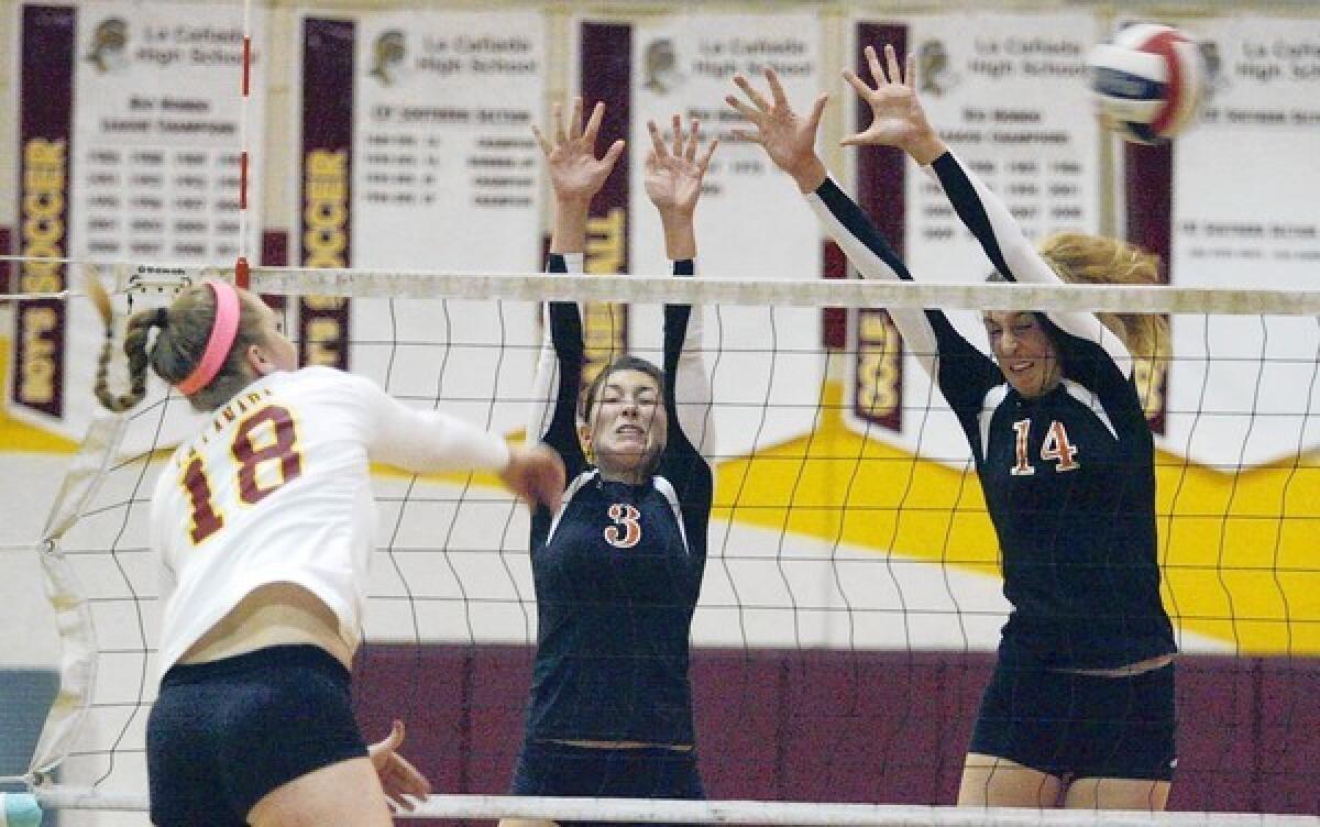 La Cañada High outside hitter Micaela Anderson, left, goes for a kill against South Pasadena's Jessica Arroyo, center, and Claire Kieffer-Wright. Anderson had a match-high 22 kills in the four-game win over South Pasadena Tuesday.