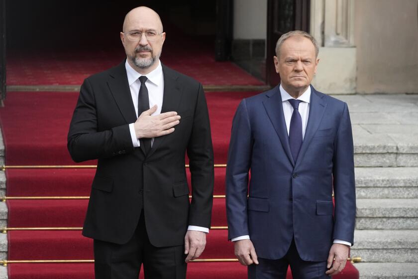 Ukrainian Prime Minister Denys Shmyhal, left, is escorted by his Polish counterpart, Donald Tusk, right, ahead of their talk in Warsaw, Poland, Thursday March 28, 2024. (AP Photo/Czarek Sokolowski)