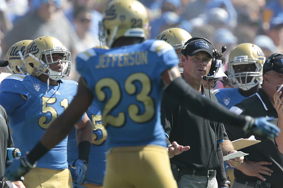 UCLA Coach Jim Mora encourages defensive back Anthony Jefferson to keep his cool after a teammate was called for a penalty early in the game against Oregon at the Rose Bowl on Oct. 11, 2014.