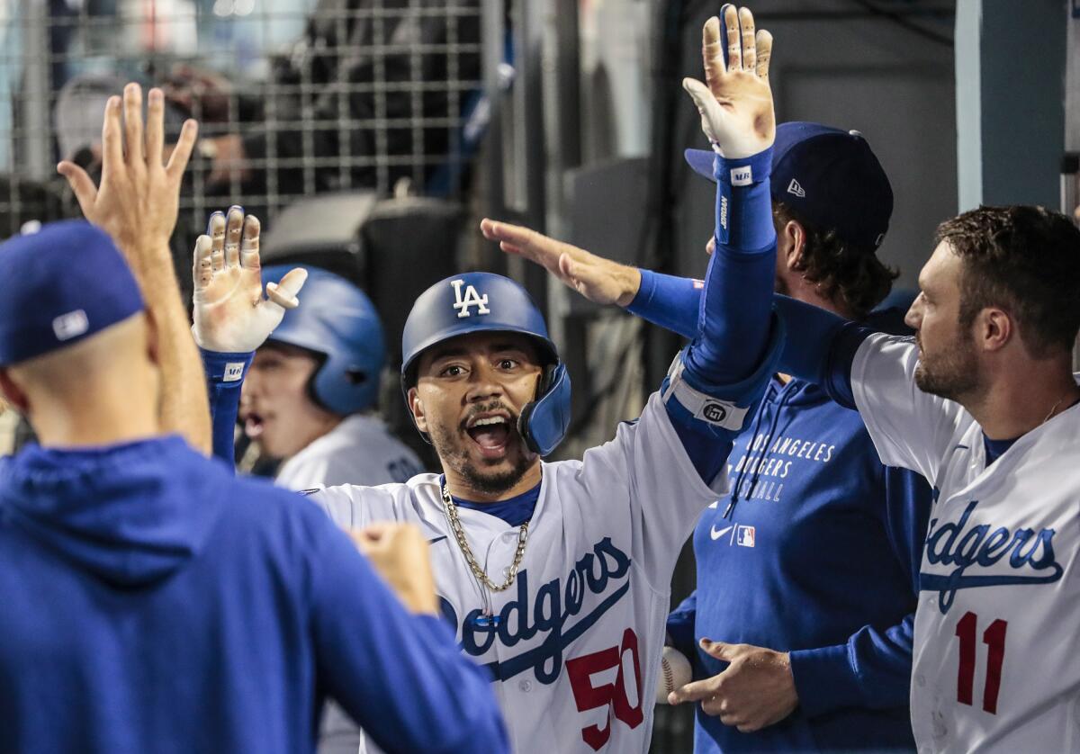 The Dodgers' Mookie Betts celebrates in the dugout after hitting a fourth-inning homer.