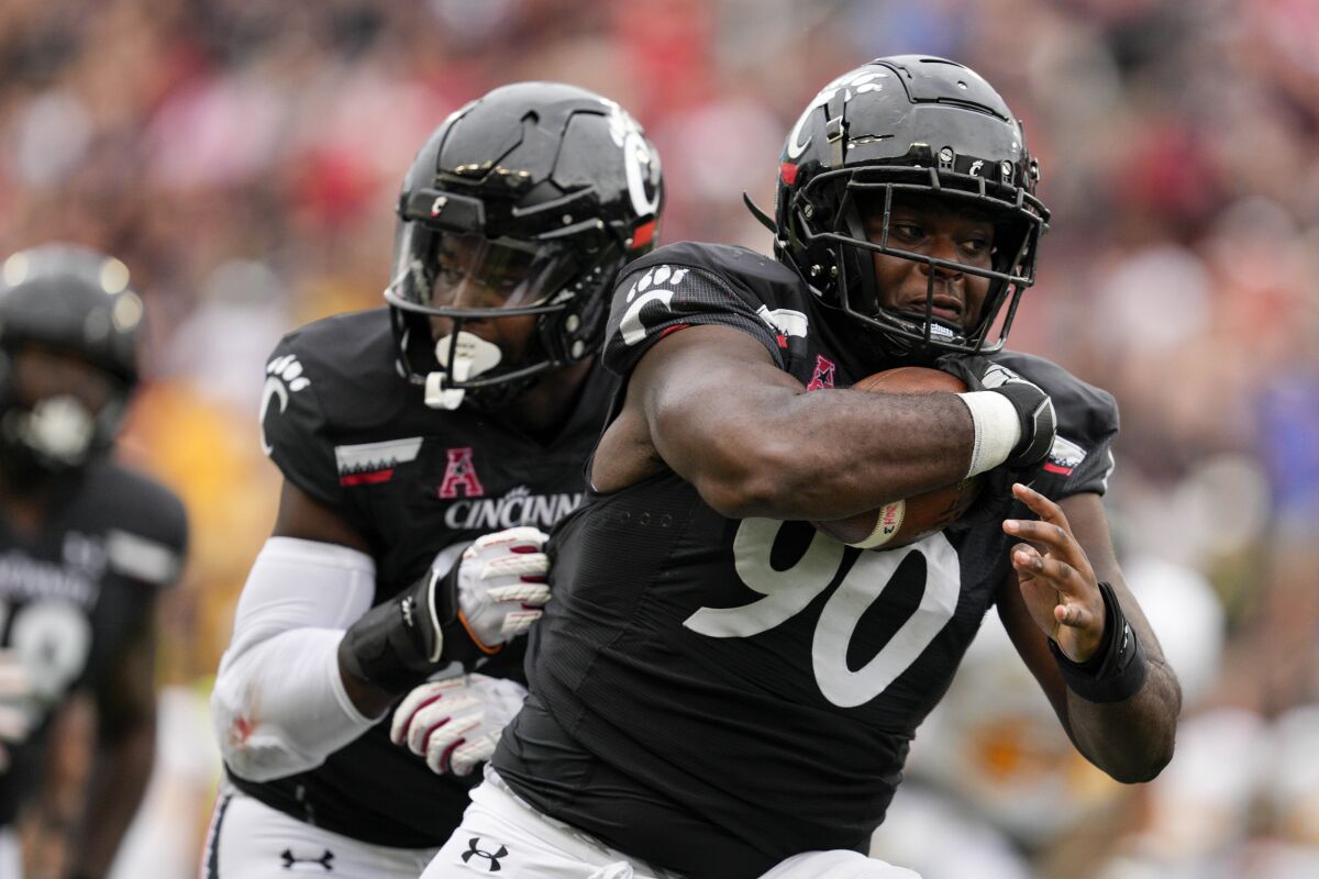 Cincinnati defensive lineman Jabari Taylor (90) runs for a touchdown after recovering a fumble during the second half of an NCAA college football game against Kennesaw State, Saturday, Sept. 10, 2022, in Cincinnati. (AP Photo/Jeff Dean)