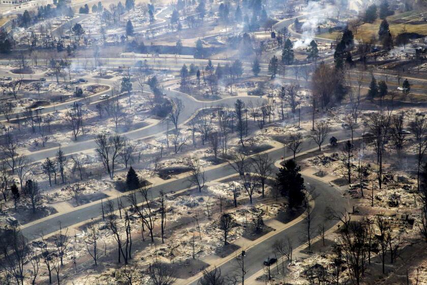 A view of a Boulder County neighborhood that was destroyed by a wildfire is seen from a Colorado National Guard helicopter during a flyover by Gov. Jared Polis on Friday, Dec. 31, 2021. Tens of thousands of Coloradans driven from their neighborhoods by a wind-whipped wildfire anxiously waited to learn what was left standing of their lives Friday as authorities reported more than 500 homes were feared destroyed. (Hart Van Denburg/Colorado Public Radio via AP, Pool)