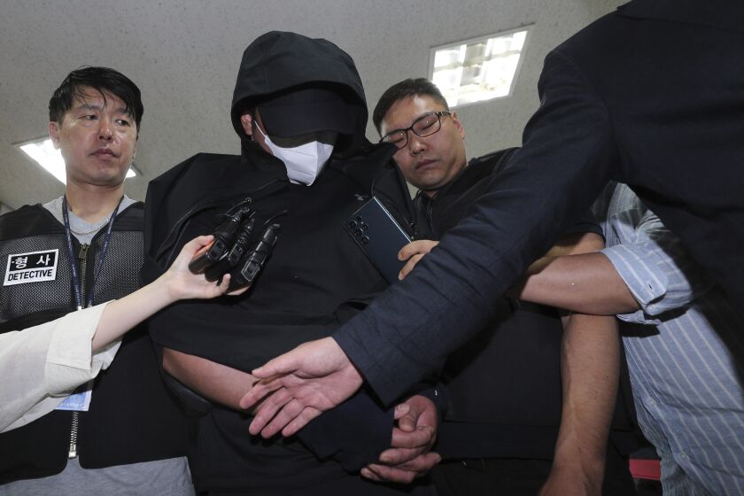 La policía lleva arrestado al hombre que abrió una puerta de emergencia durante un vuelo en Corea del Sur, en Daegu el domingo 28 de mayo de 2023. (Yun Kwan-shick/Yonhap vía AP)