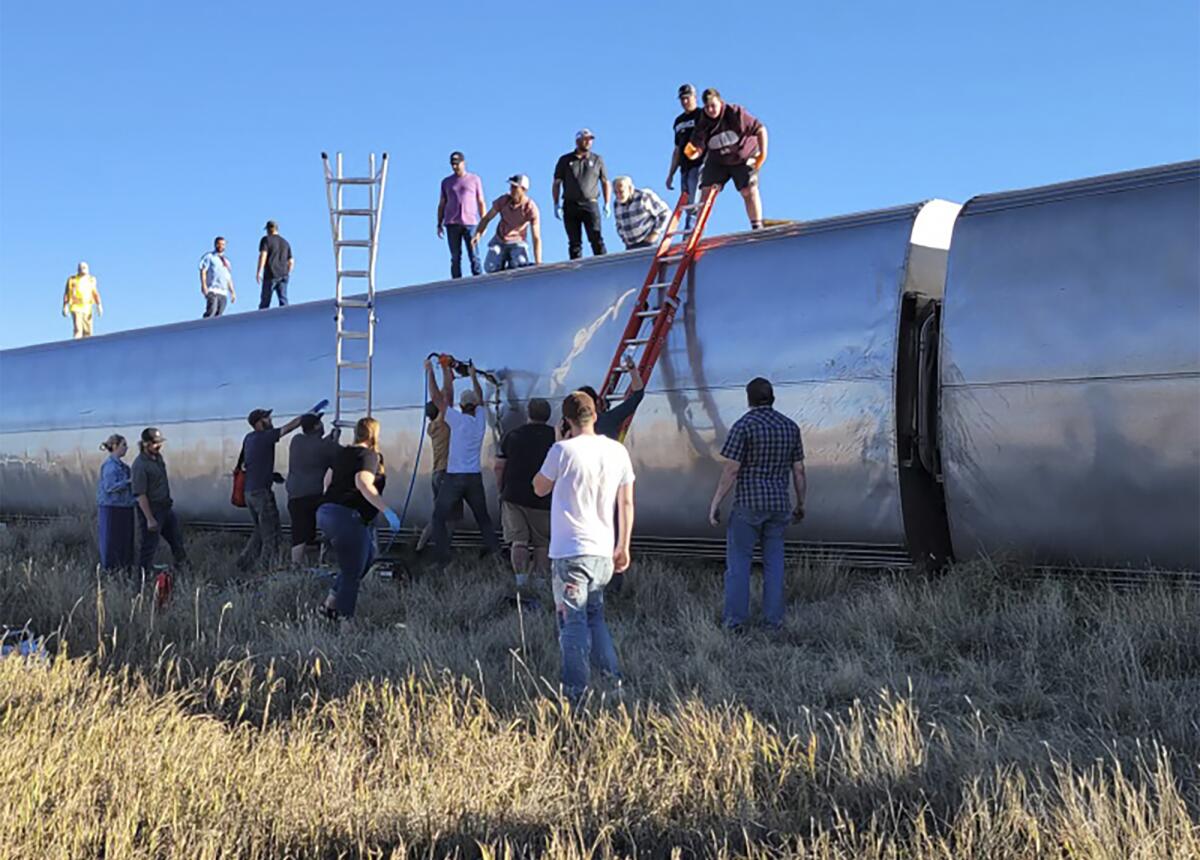People standing next to and on top of a train car