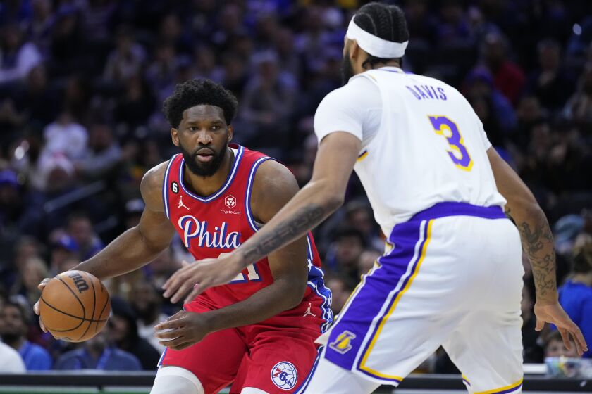 Philadelphia 76ers' Joel Embiid, left, tries to get past Los Angeles Lakers' Anthony Davis during the first half of an NBA basketball game, Friday, Dec. 9, 2022, in Philadelphia. (AP Photo/Matt Slocum)