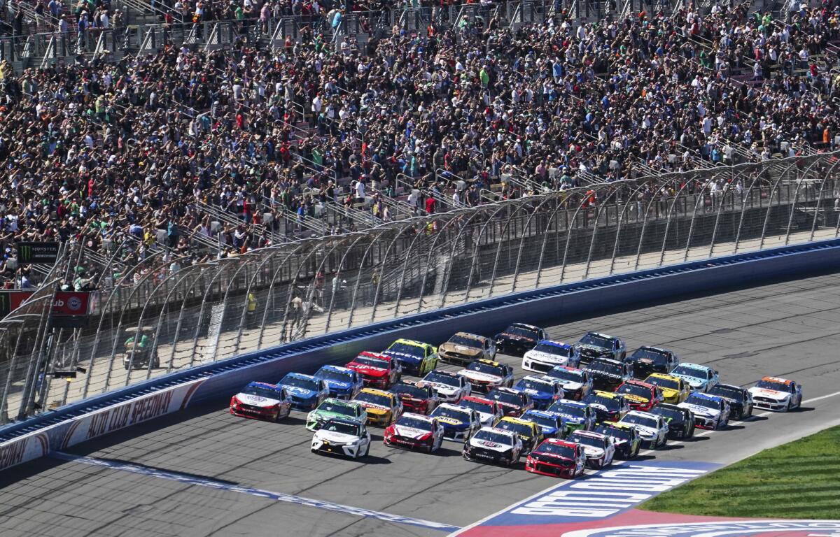 NASCAR Cup Series cars line up five wide in a salute to fans during pace laps.