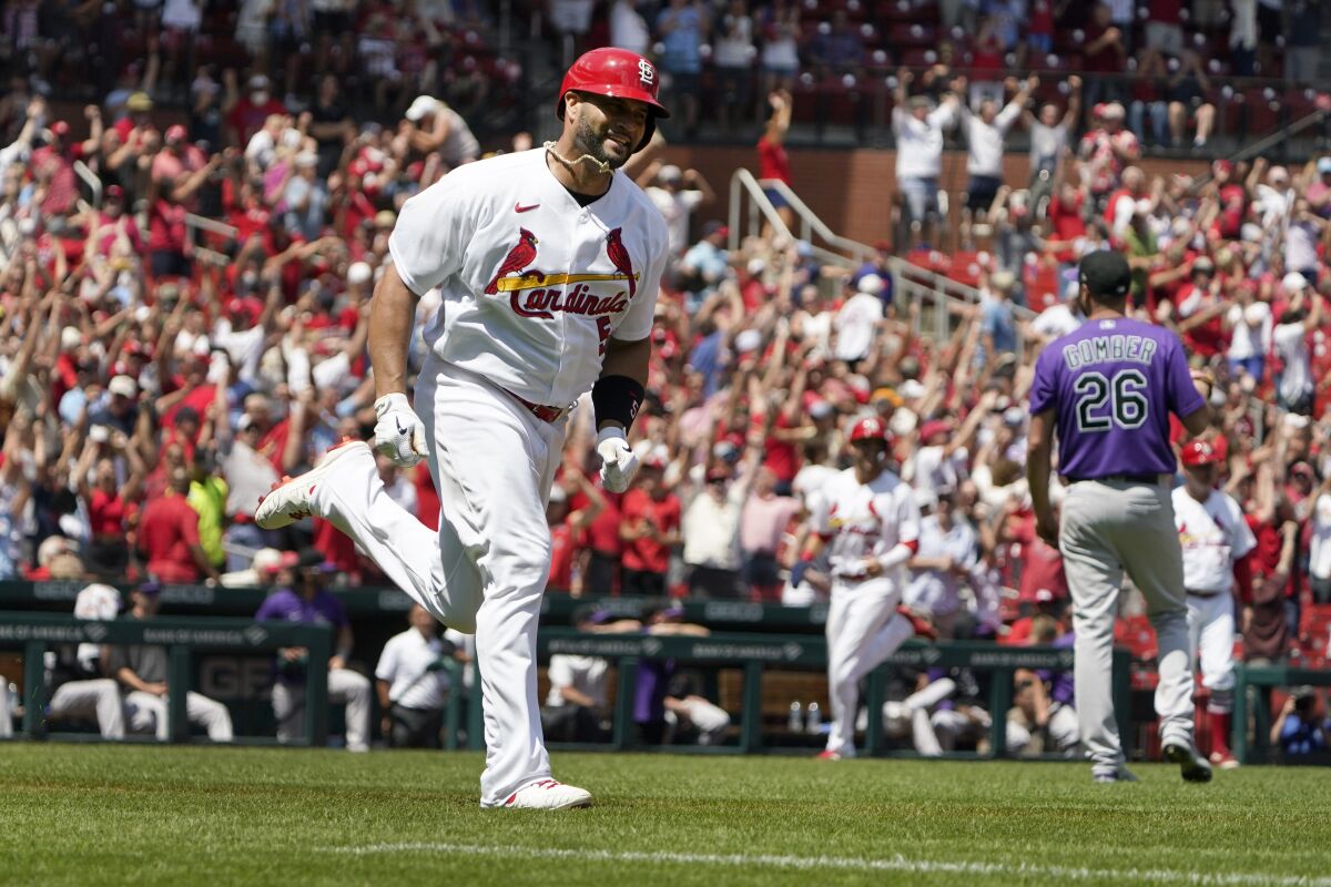 St. Louis Cardinals' Albert Pujols, left, rounds the bases after hitting a grand slam off Colorado Rockies starting pitcher Austin Gomber (26) during the third inning of a baseball game Thursday, Aug. 18, 2022, in St. Louis. (AP Photo/Jeff Roberson)