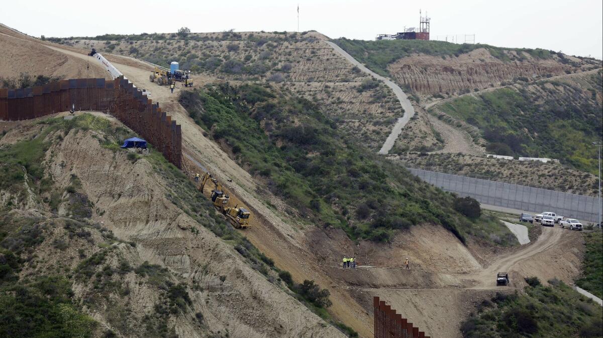 Construction crews replace a section of the primary wall separating San Diego, right, and Tijuana, left.