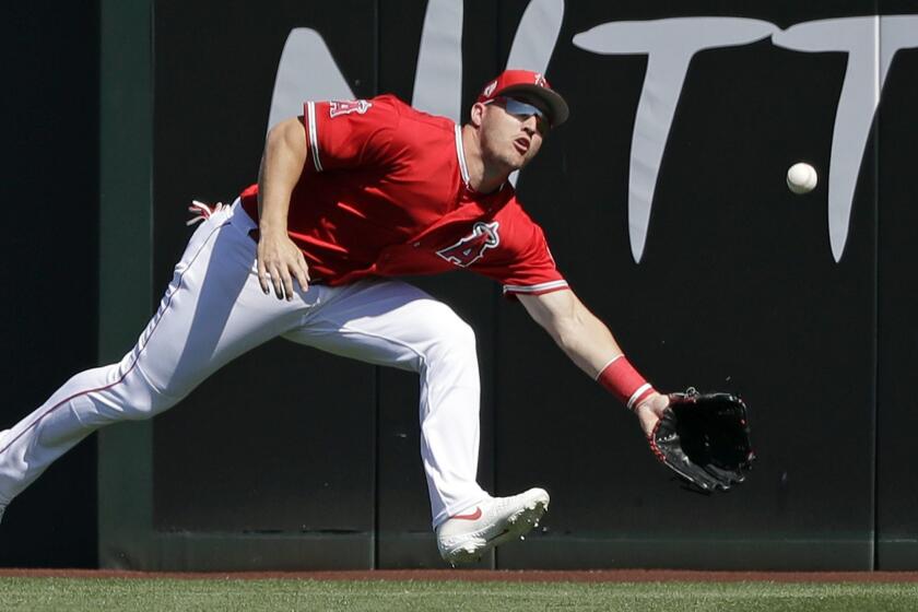 Los Angeles Angels center fielder Mike Trout eyes but misses snagging a fly ball from Chicago Cubs' Willson Contreras for an error in the first inning of a spring training baseball game Tuesday, March 5, 2019, in Tempe, Ariz. Contreras, who doubled, scored after advancing on the error. (AP Photo/Elaine Thompson)