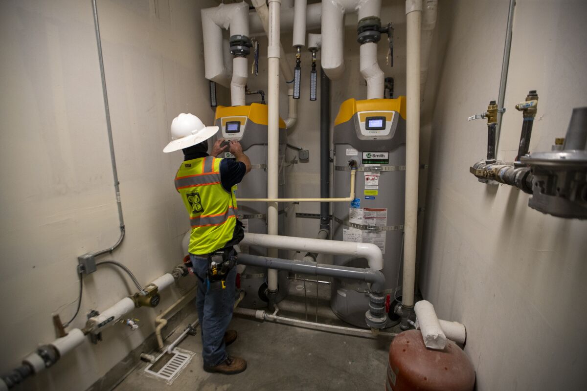 Everett Reid, assistant superintendent, views high-efficiency natural gas boilers at Day Creek Villas.