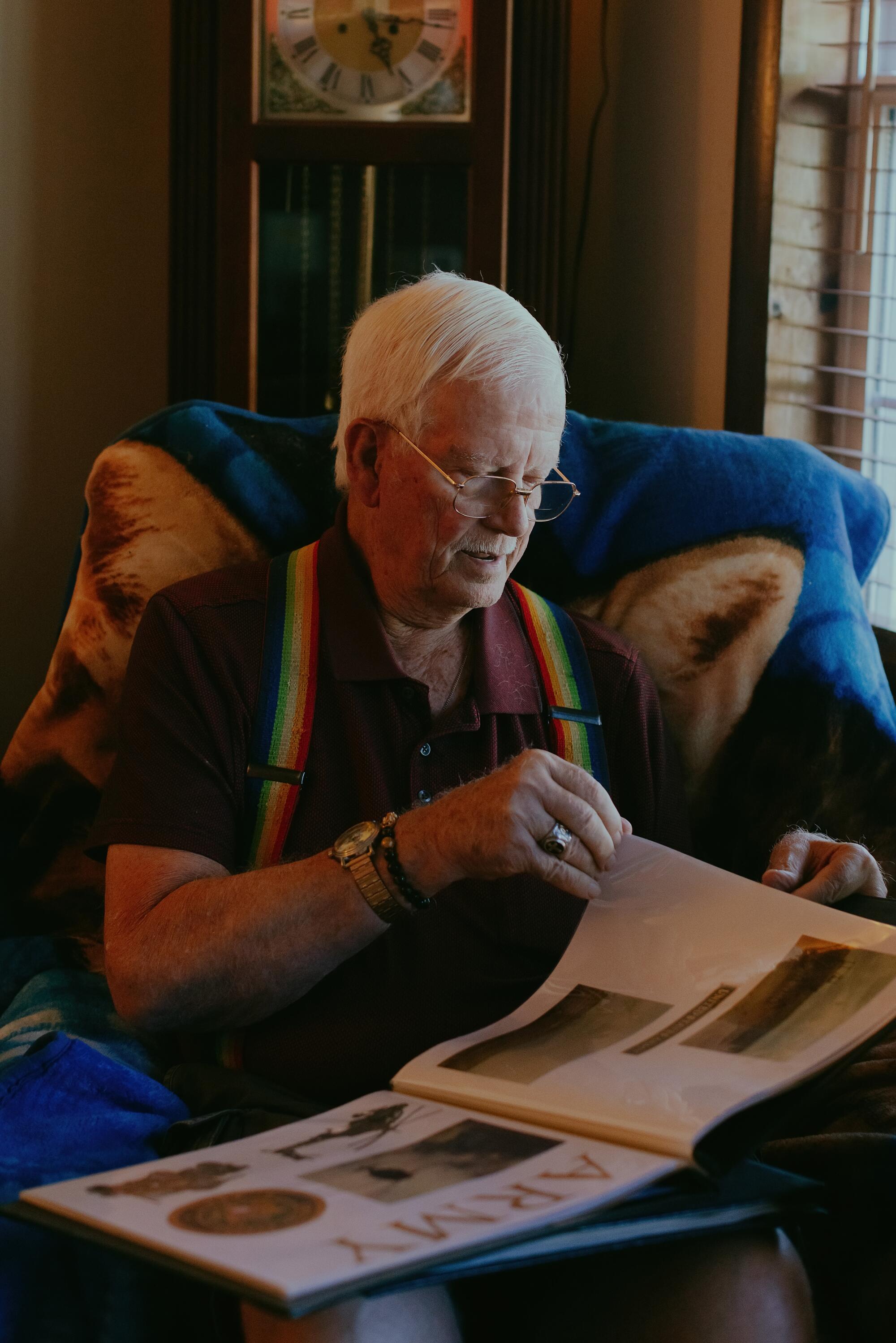 Gene Ulrich goes through an album of photos from his days in the Army at his home in Bunceton, Mo.