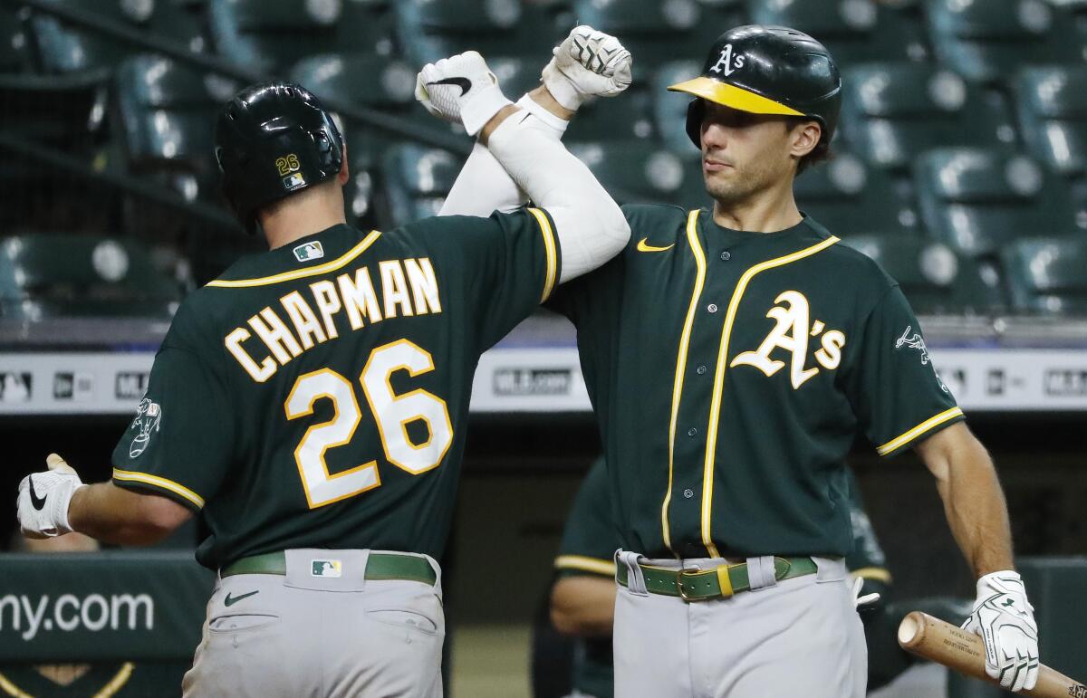Oakland Athletics' Matt Chapman celebrates with Matt Olson after hitting a home run against the Houston Astros during the fourth inning of the second baseball game of a doubleheader Saturday, Aug. 29, 2020, in Houston. (Kevin M. Cox/The Galveston County Daily News via AP)