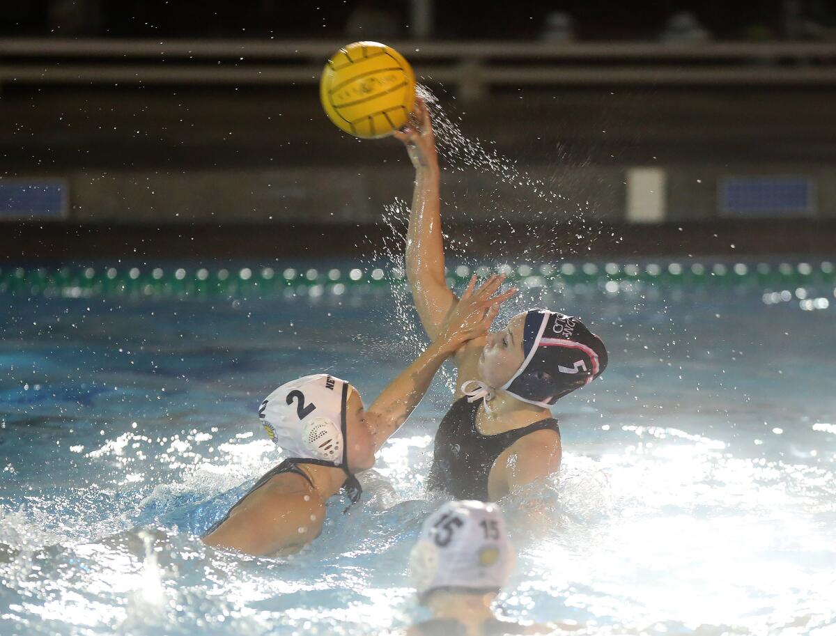 Newport Harbor's Taylor Smith (2) tries to block the shot of Corona del Mar's Emily Cloherty (5) during the Battle of the Bay match on Thursday.