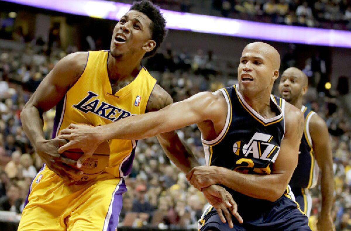 Lakers guard Nick Young is fouled by Jazz forward Richard Jefferson during a preseason game.
