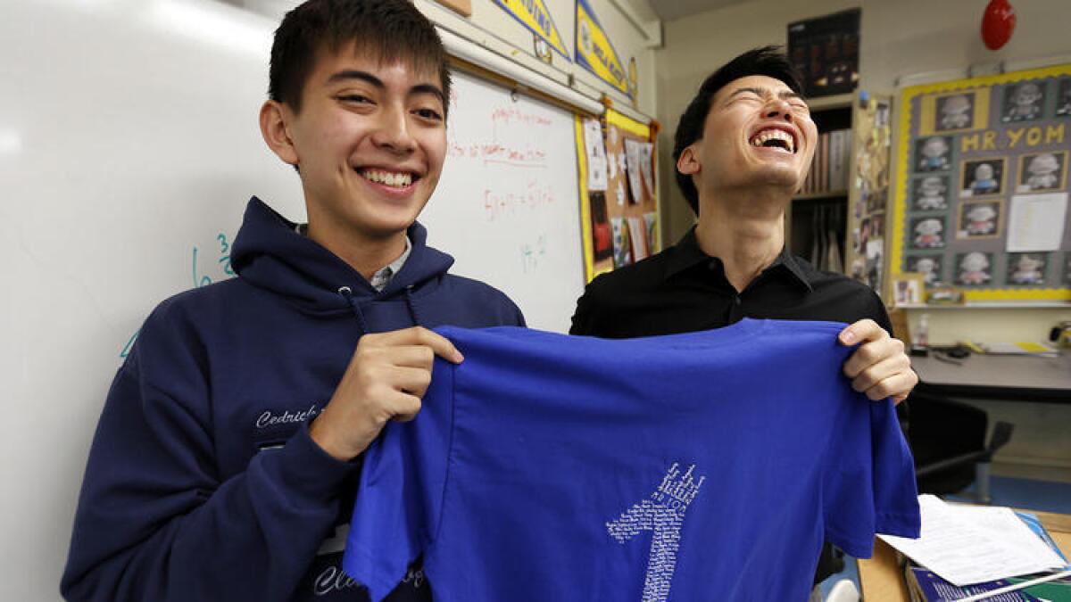 Cedrick Argueta, a la izquierda, un estudiante de último año en Lincoln High School en Lincoln Heights y su instructor de matemáticas, Anthony Yom, muestra una de las camisetas de Calculo AP que utilizaron los estudiantes en el pasado examen en primavera.