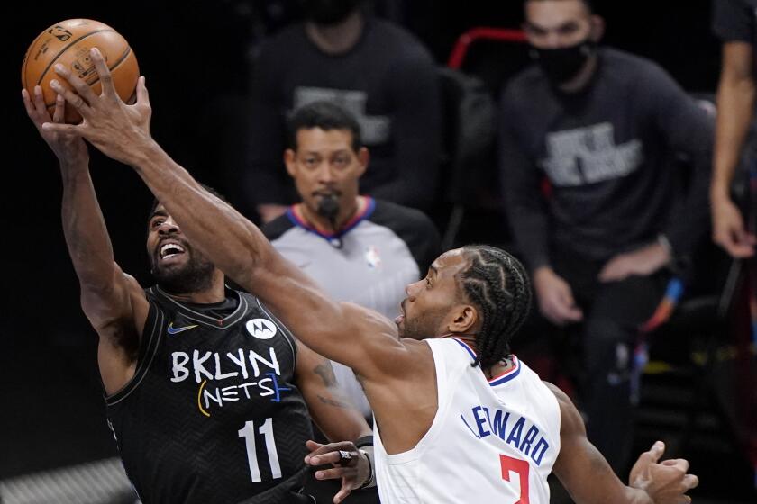 Los Angeles Clippers forward Kawhi Leonard (2) defends against Brooklyn Nets guard Kyrie Irving (11) during the first quarter of an NBA basketball game Tuesday, Feb. 2, 2021, in New York. (AP Photo/Kathy Willens)