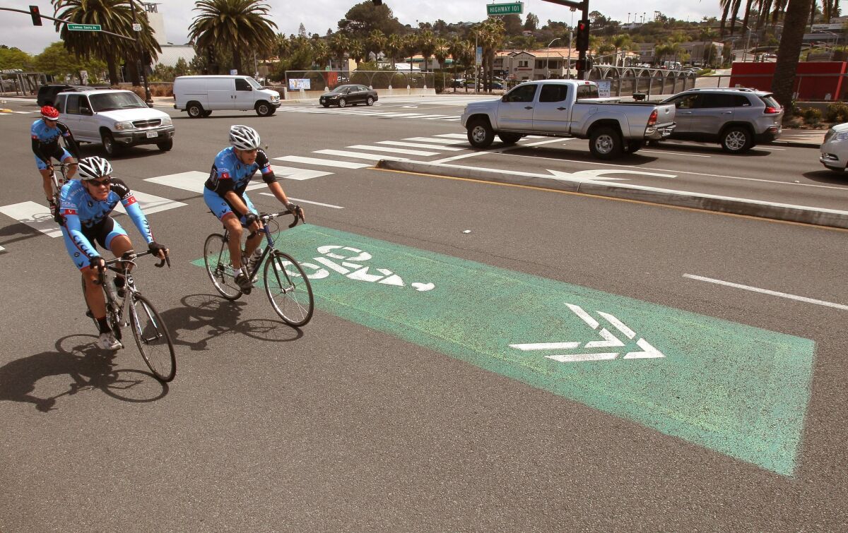 Cyclists ride past one of the "sharrow" markings on Highway 101 near Lomas Santa Fe Drive in Solana Beach.