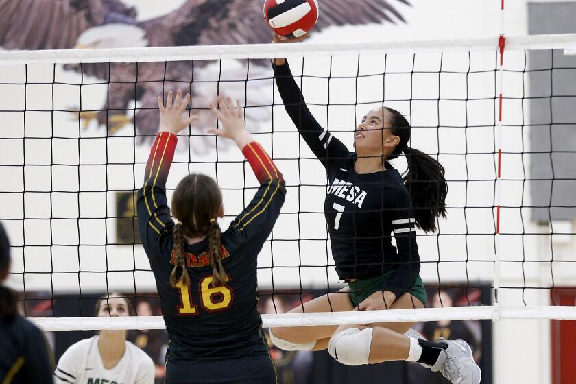 Costa Mesa's Aubrey Spallone (7) tips a ball over the net for point during girls' Orange Coast League Battle of the Bay volleyball game against Estancia on Tuesday.