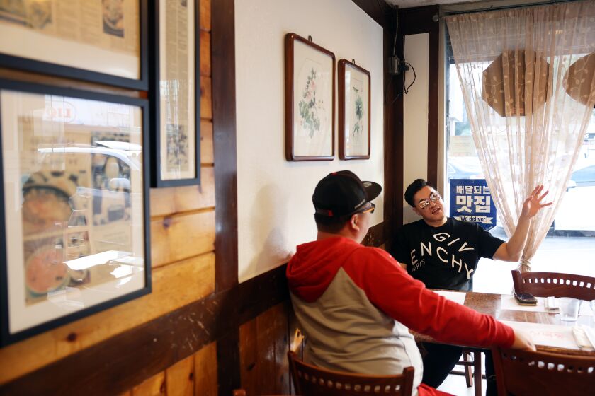 LOS ANGELES, CA - JANUARY 26: Brian Oh, left, and Ro Chei, right, eat at Seongbukdong a restaurant serving traditional Korean food on 6th Street between Western and Vermont on Wednesday, Jan. 26, 2022 in Los Angeles, CA. "The dishes bring back childhood memories growing up in K-Town," Chei said. (Dania Maxwell / Los Angeles Times)