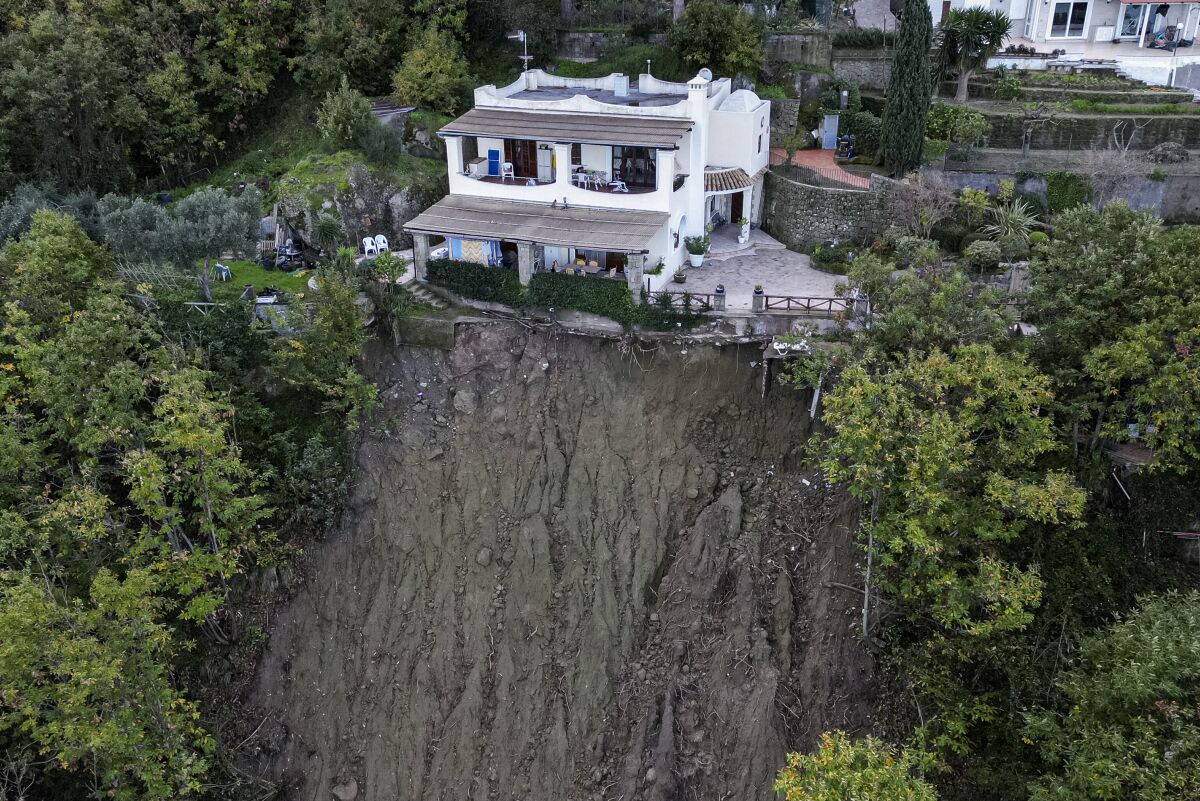 A house is left standing on the edge of a landslide in Casamicciola, on the southern Italian island of Ischia, in this picture taken Sunday, Nov. 27, 2022. Exceptionally heavy rain caused a chunk of Mount Epomeo to come crashing down before dawn on Saturday, gaining speed as it entered the populated port town of Casamicciola, where it demolished buildings and carried cars and buses into the sea leaving at least eight people dead and more missing. Some 30 houses were inundated by the mud and water, and more than 200 residents in the town of 8,300 remain homeless, according to officials. (AP Photo/Salvatore Laporta)