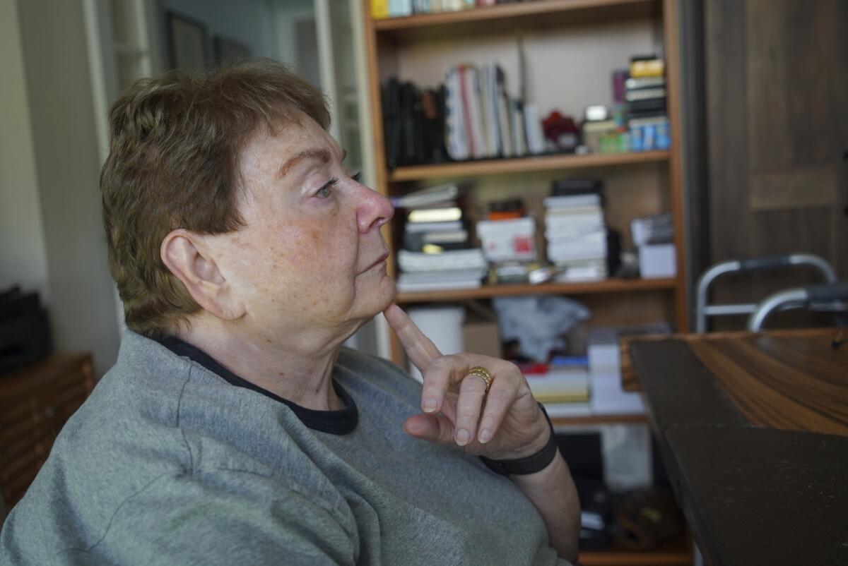 A woman in an office sits pensively 