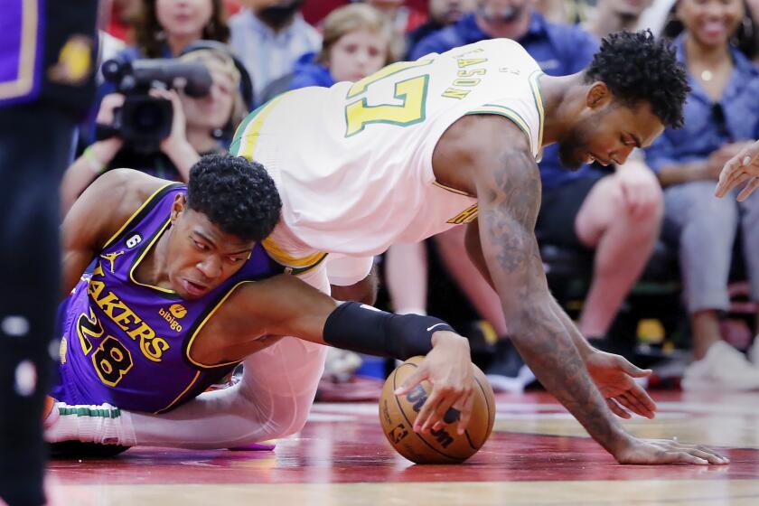 Los Angeles Lakers forward Rui Hachimura (28) and Houston Rockets forward Tari Eason (17) dive for a loose ball during the first half of an NBA basketball game, Sunday, April 2, 2023, in Houston. (AP Photo/Michael Wyke)