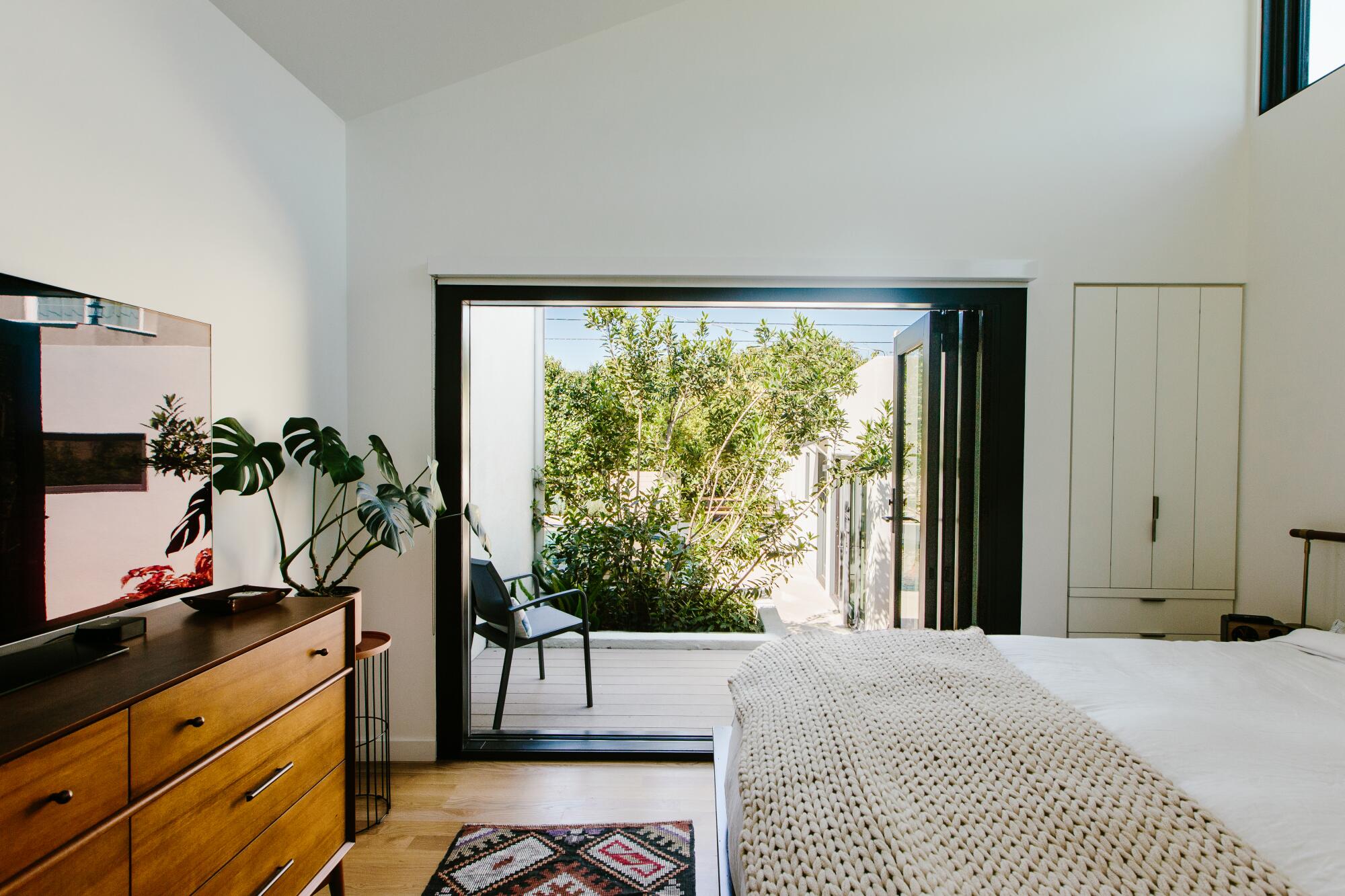 A master bedroom overlooking a deck and yard