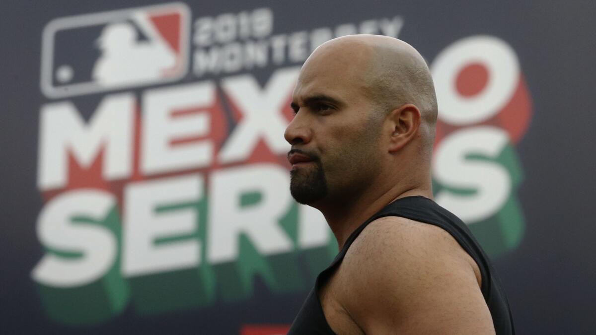 Angels' Albert Pujols walks in front a billboard during a practice session a day ahead of the Angels' two-game series against the Houston Astros, in Monterrey, Mexico.