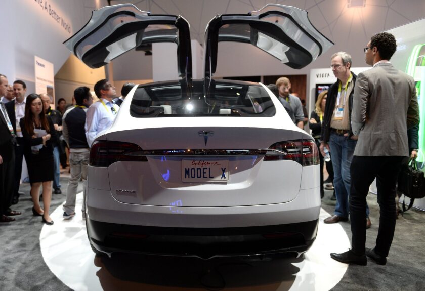 Visitors to the 2015 Consumer Electronics Show in Las Vegas check out a prototype of Tesla's upcoming Model X crossover. Similar to the Model S sedan, the X is due to begin shipping late this year. It will be followed by a more affordable Model 3 sedan.