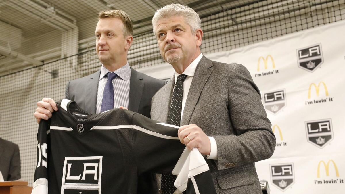 Kings general manager Rob Blake, left, presents a personalized team jersey to new head coach Todd McLellan at a news conference on April 17, 2019, at the Toyota Sports Center in El Segundo.