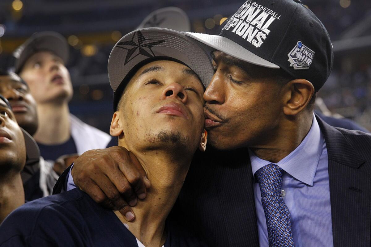 Connecticut Coach Kevin Ollie gives player Shabazz Napier a kiss following the Huskies' 60-54 win over Kentucky in the NCAA men's basketball championship game
