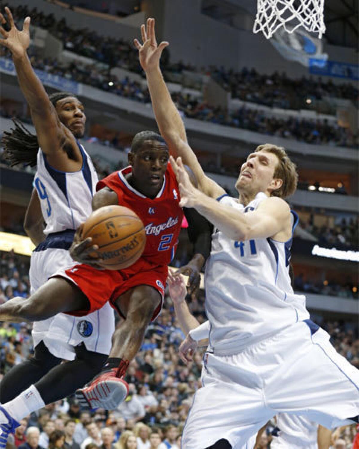 Dallas forwards Jae Crowder, left, and Dirk Nowitzki defend as Clippers guard Darren Collison looks to pass back in January.