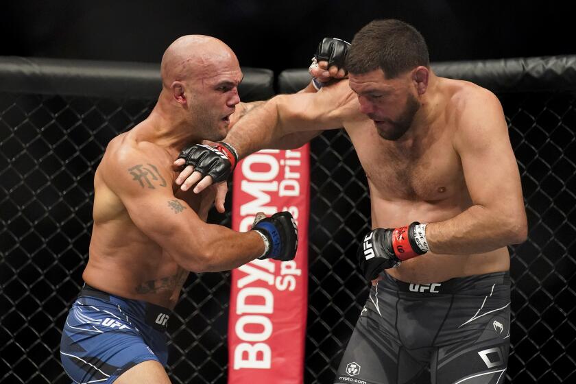 Robbie Lawler, left, throws a punch against Nick Diaz during a middleweight mixed martial arts bout at UFC 266, Saturday, Sept. 25, 2021, in Las Vegas. (AP Photo/John Locher)