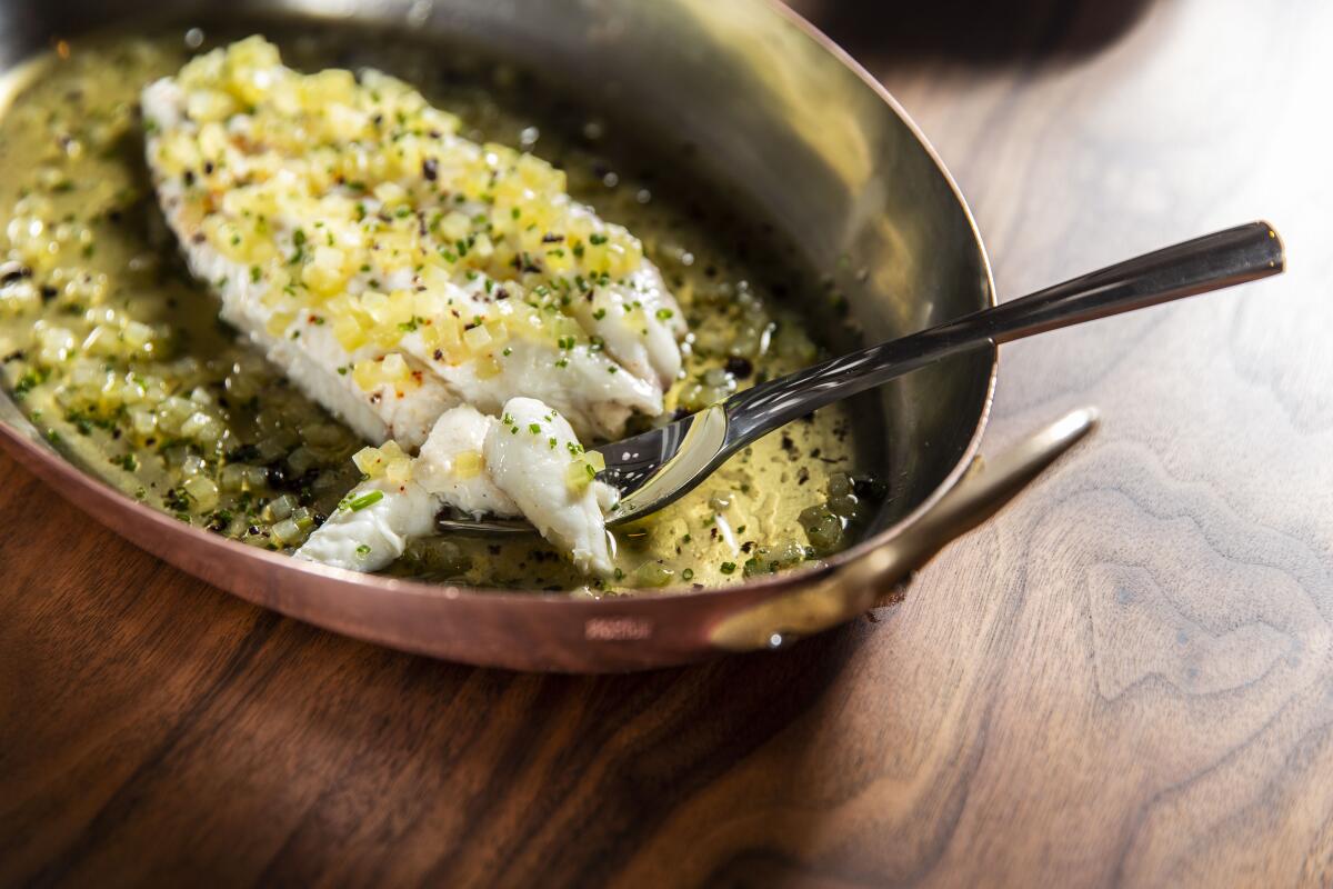 Whole Dover sole with green tomato-infused butter, chopped dehydrated black olives and fermented green tomato juice.