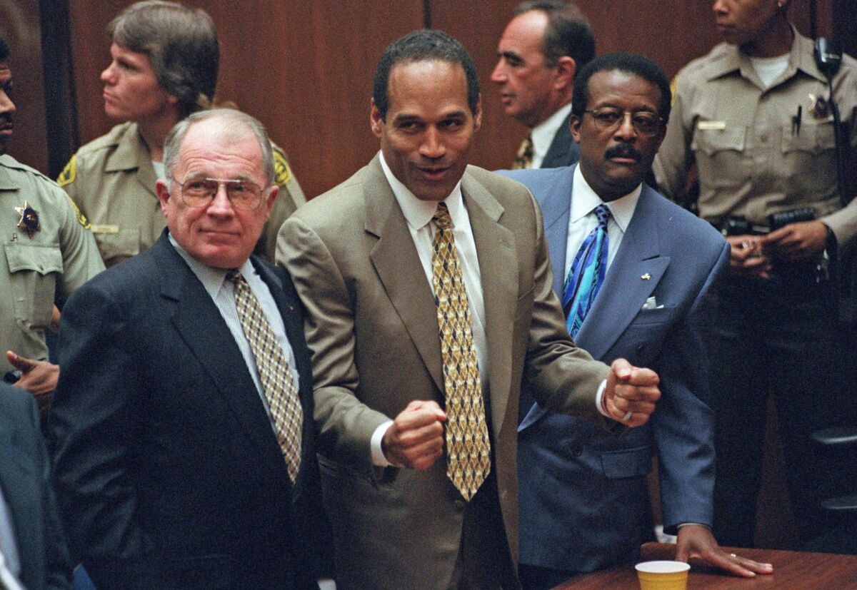 O.J. Simpson, center, reacts as he is found not guilty of killing his ex-wife Nicole Brown and her friend Ron Goldman, as members of his defense team, F. Lee Bailey, left, and Johnnie Cochran Jr., right, look on, in court in Los Angeles on Oct. 3, 1995.