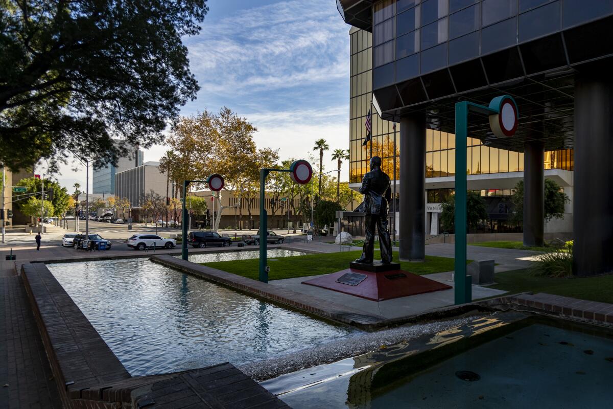  A statue near a shallow reflecting pool outside a building